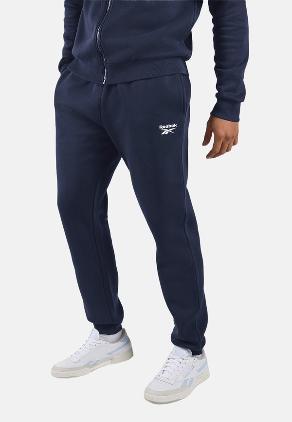 Reebok ANDRE SMALL LOGO CUFFED PANTS-BLUE . - Tracksuit bottoms - vector navy